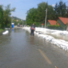 Homokzsákhegyek, hömpölygő víz az utakon